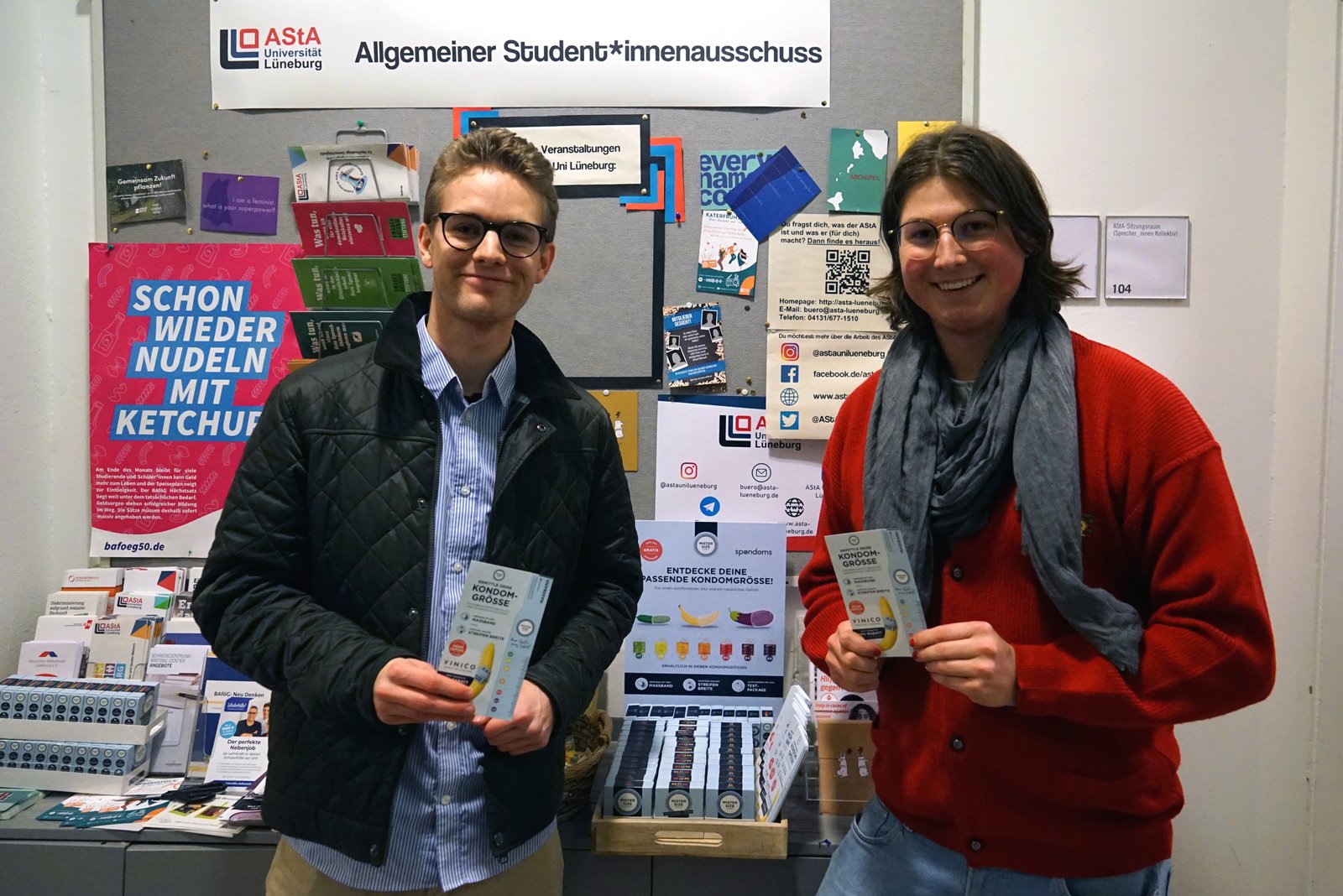Луїс зі Spondoms (ліворуч) відкриває безкоштовний автомат з презервативами разом з Максом з AStA Університету Леуфана в Люнебурзі (праворуч).